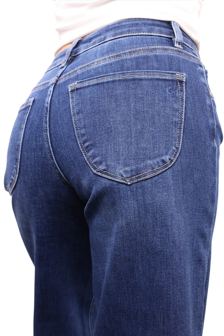 Close-up back view of a person wearing dark blue denim jeans, showing the back pocket and waistband against a plain white background.