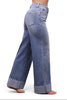 A person shown from the waist down wearing light blue wide-leg jeans with rolled cuffs, photographed against a plain white studio background.