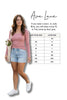 Woman wearing a pink top and light blue shorts with a size chart on a white background