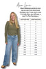 Woman wearing a green top and blue jeans next to a size chart for Judy Blue and Constance clothing lines.