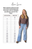 Woman wearing a brown sweater and light blue jeans with a size chart on a white background