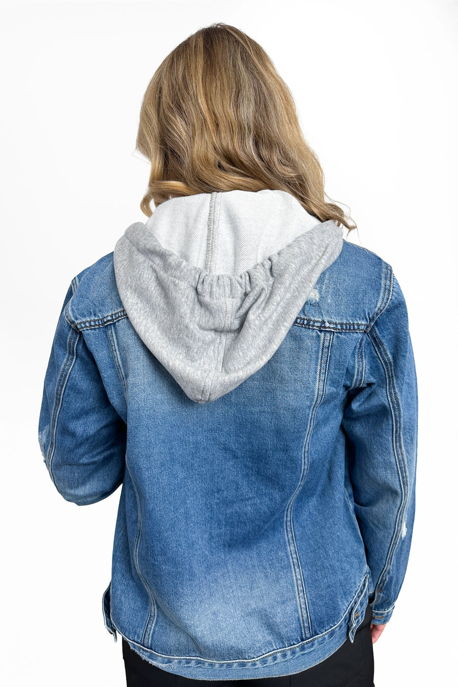 Blue denim jacket with gray hood worn by a person on a white background