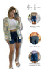 Woman taking a mirror selfie wearing denim shorts with Ava Lane branding and product details.