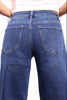 Rear view of a person wearing blue denim jeans with a light pink top, shown against a plain white background.