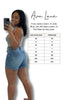 Woman taking a selfie wearing denim shorts with a size chart for Ava Lane clothing brand.