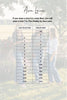 Size conversion chart between Judy Blue and Shelby's sizes with a blurred background of people and trees.