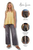 Woman wearing a yellow top and dark jeans with product features highlighted on the right.