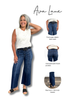 A woman modeling blue wide-leg jeans with a white sleeveless knit top on a white background, alongside three inset detail views labeled Front seam detail+ dark wash, Oversized patch back pockets, and Raw hem + 26.5 inch inseam.