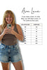 Woman taking a selfie wearing a brown tank top and denim shorts, with a size chart for Ava Lane clothing on a white background.