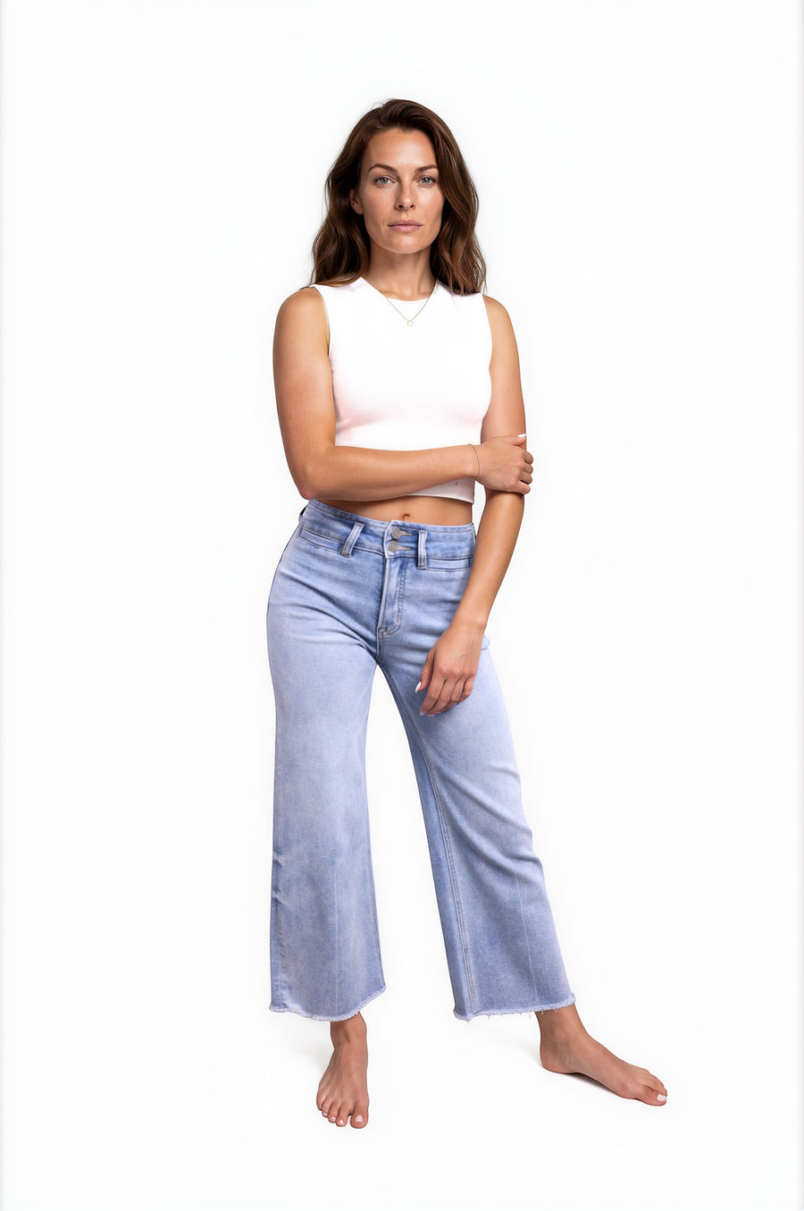 Ava Lane Boutique light wash cropped wide leg jeans with tummy control and raw hem. Model is wearing a white crop top.